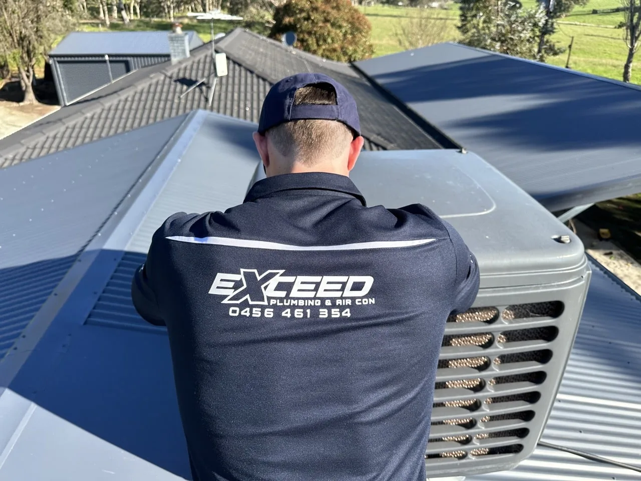 Technician on a roof servicing an evaporative cooling unit